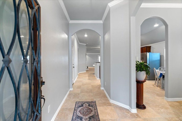 hall featuring arched walkways, ornamental molding, baseboards, and stone finish flooring
