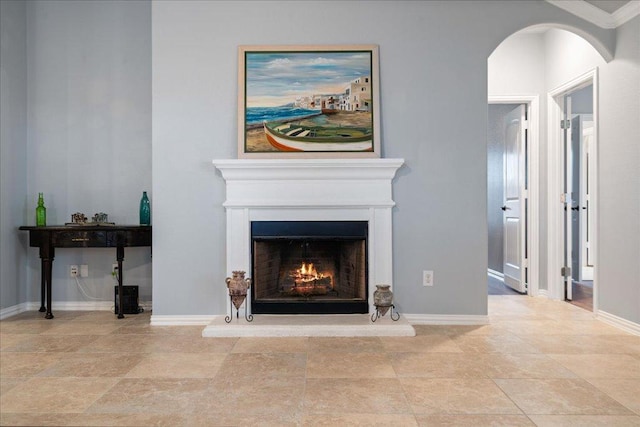 living area featuring a warm lit fireplace and baseboards