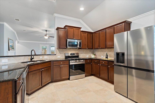 kitchen featuring crown molding, a sink, dark stone counters, and stainless steel appliances