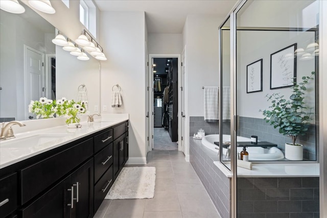 bathroom with a sink, tile patterned flooring, double vanity, and a bath