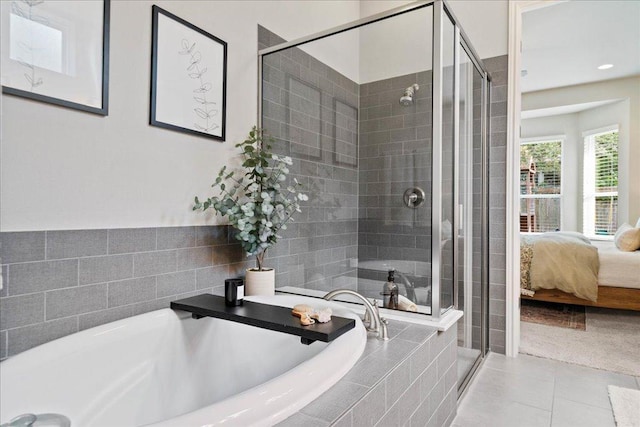 ensuite bathroom featuring a shower stall, a bath, and connected bathroom