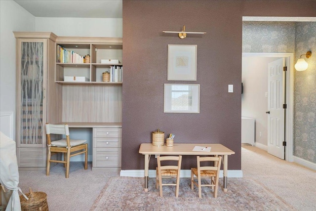 office featuring baseboards, carpet flooring, and built in desk