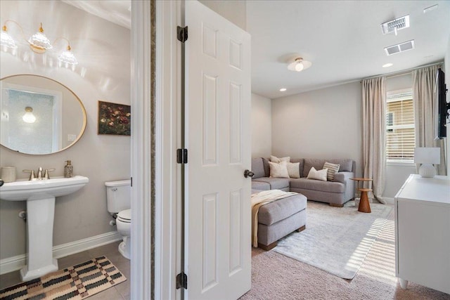 bathroom featuring baseboards, toilet, and visible vents
