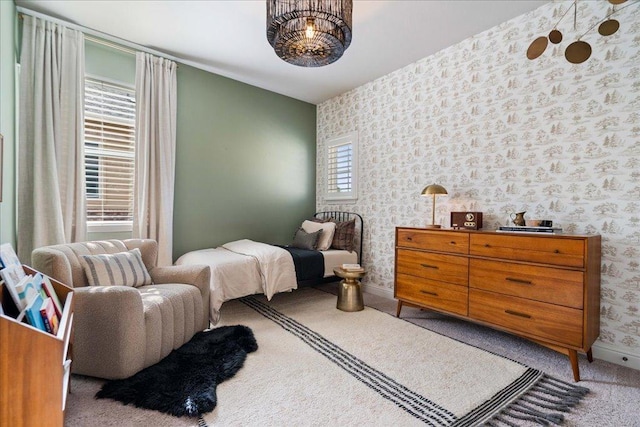 carpeted bedroom with wallpapered walls and baseboards