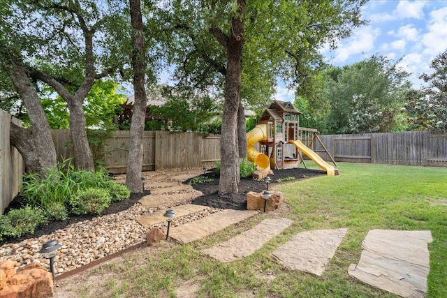 view of yard featuring a fenced backyard and a playground