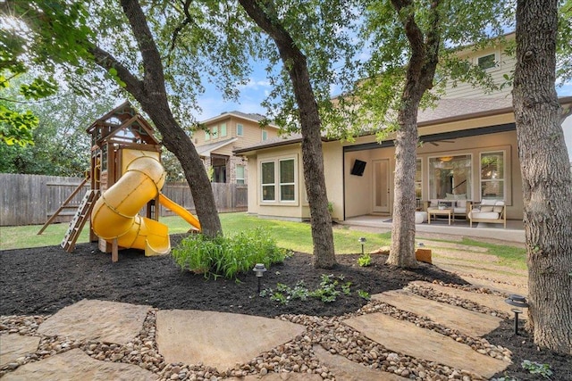 view of jungle gym featuring fence, an outdoor living space, and a patio area