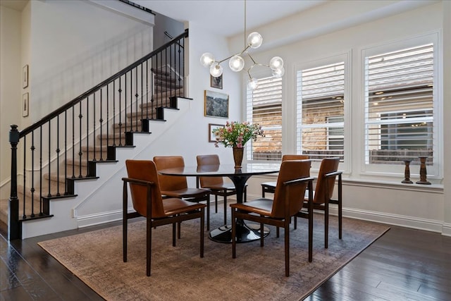 dining room featuring baseboards, stairs, hardwood / wood-style floors, and an inviting chandelier