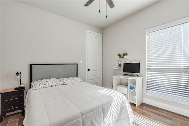 bedroom featuring baseboards, a ceiling fan, and wood finished floors