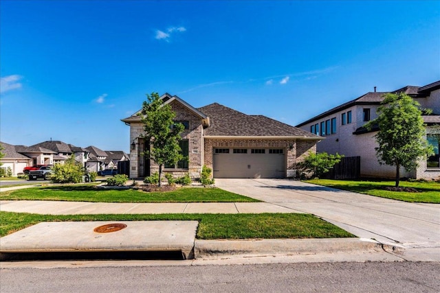170 Alice Jane Ln, Buda, TX 78610 - view of front of house with an attached garage, concrete driveway, brick siding, a front lawn, and a residential view