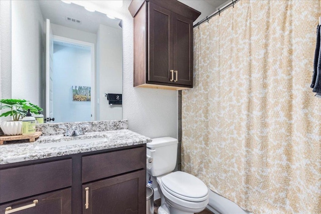 full bathroom with vanity, a shower with curtain, toilet, and visible vents