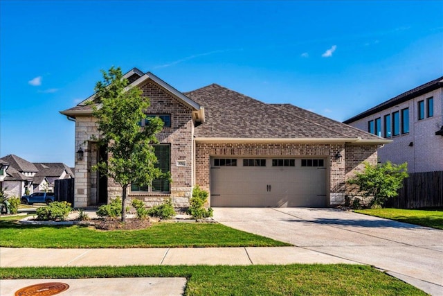 view of front of house with brick siding, an attached garage, fence, and driveway