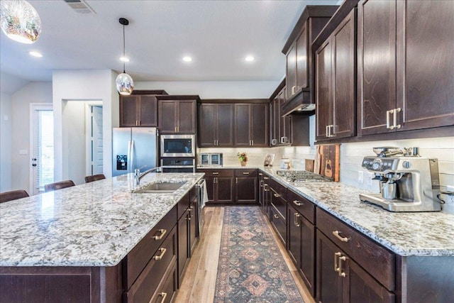 170 Alice Jane Ln, Buda, TX 78610 - kitchen featuring appliances with stainless steel finishes, under cabinet range hood, dark brown cabinets, light stone counters, and recessed lighting
