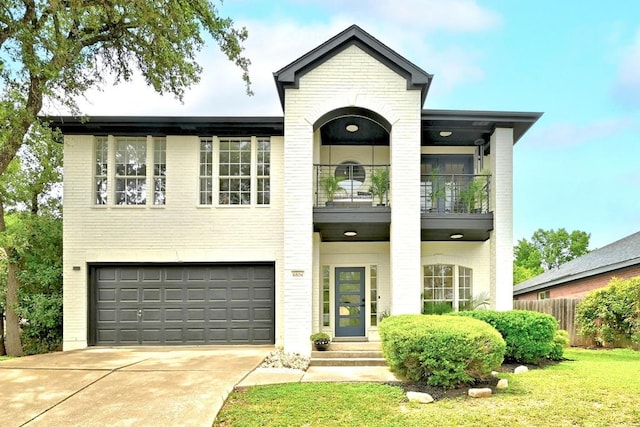 view of front of home featuring an attached garage, concrete driveway, brick siding, and a balcony
