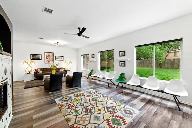 living area featuring visible vents, ceiling fan, and wood finished floors