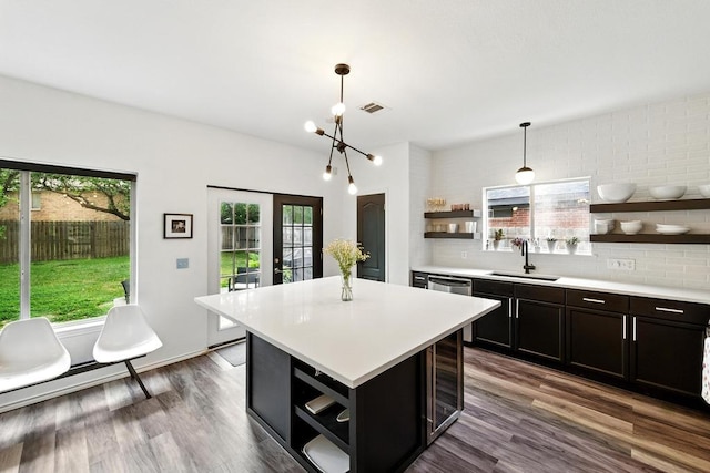 kitchen with a sink, light countertops, open shelves, and a healthy amount of sunlight