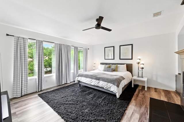 bedroom with ceiling fan, visible vents, and light wood-type flooring