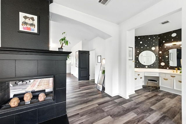 interior space featuring visible vents, a sink, dark wood-style flooring, and baseboards