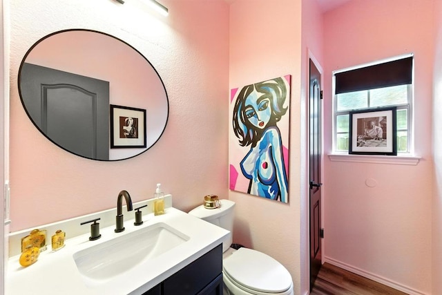 bathroom featuring vanity, wood finished floors, and toilet