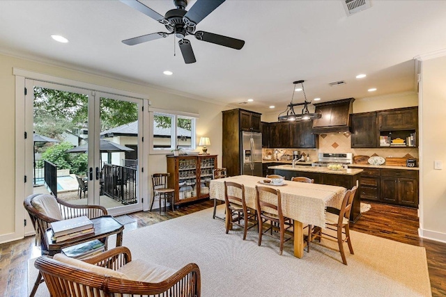 dining area featuring ceiling fan, visible vents, ornamental molding, and dark wood-type flooring