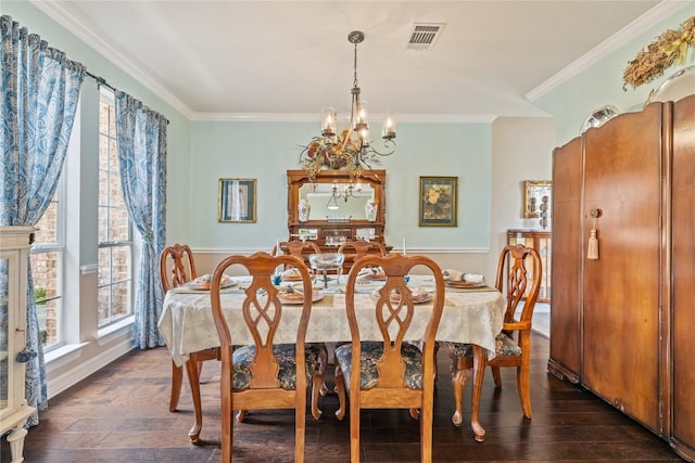dining room with ornamental molding, dark wood-type flooring, visible vents, and a chandelier