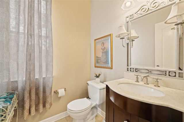 bathroom featuring baseboards, tile patterned floors, vanity, and toilet