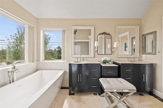 bathroom with a soaking tub and vanity