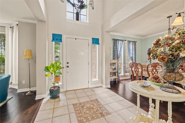 entryway with ornamental molding, a healthy amount of sunlight, and hardwood / wood-style floors