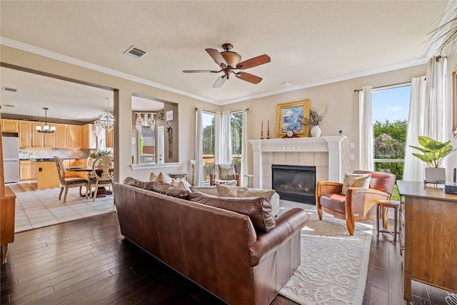 living area with hardwood / wood-style floors, visible vents, a wealth of natural light, and a fireplace