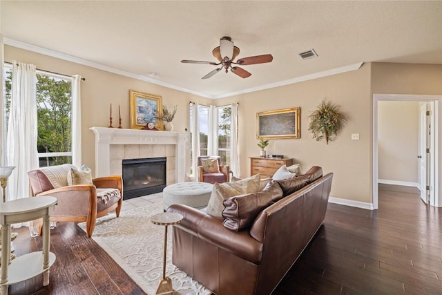 living room featuring a ceiling fan, visible vents, a fireplace, baseboards, and dark wood-type flooring