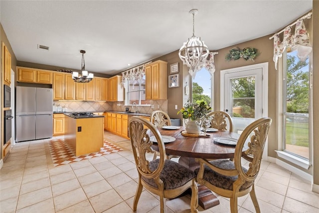 dining space with a notable chandelier, light tile patterned floors, and visible vents