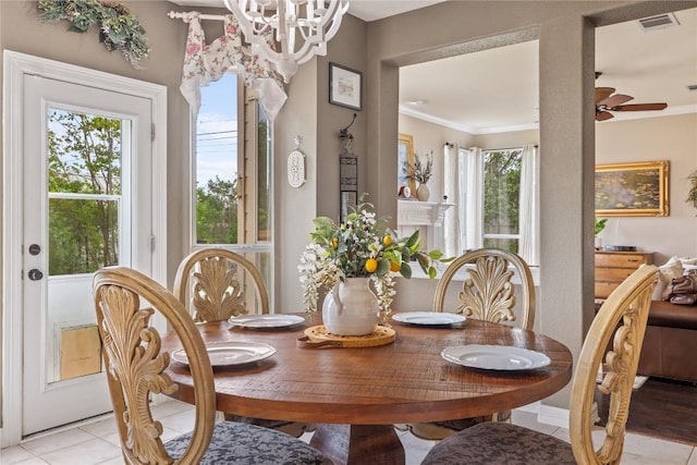 dining space featuring visible vents, ornamental molding, ceiling fan with notable chandelier, and light tile patterned flooring