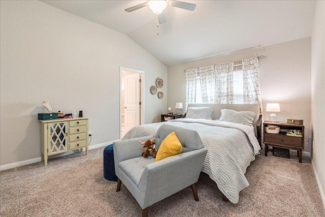carpeted bedroom featuring baseboards, ensuite bathroom, vaulted ceiling, and ceiling fan