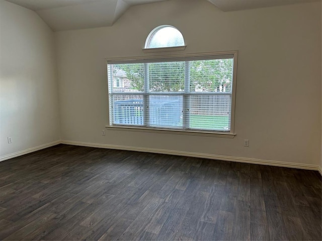 unfurnished room with dark wood-style flooring, baseboards, and vaulted ceiling