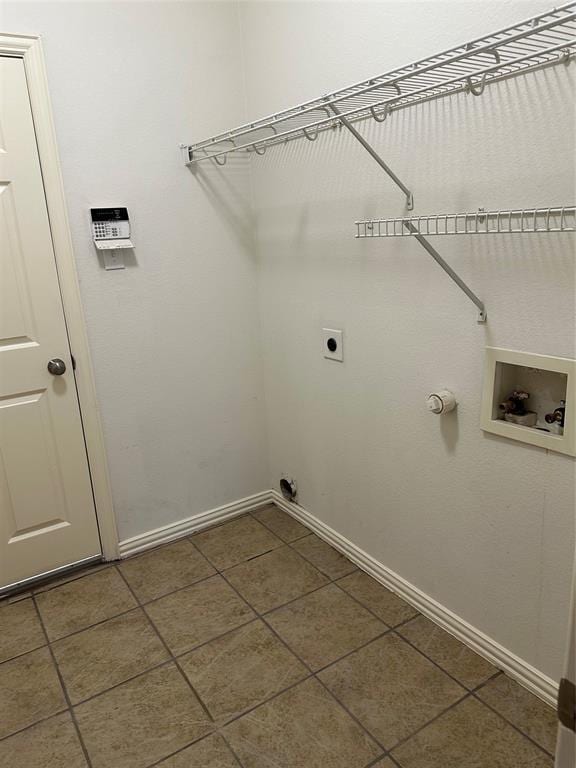 clothes washing area featuring laundry area, hookup for a washing machine, baseboards, dark tile patterned floors, and hookup for an electric dryer