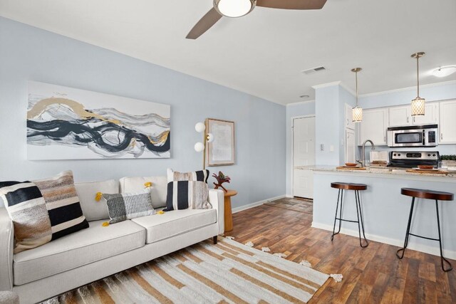 8888 Tallwood Dr Unit 1110, Austin, TX 78759 - living area featuring crown molding, dark wood-style flooring, ceiling fan, baseboards, and visible vents