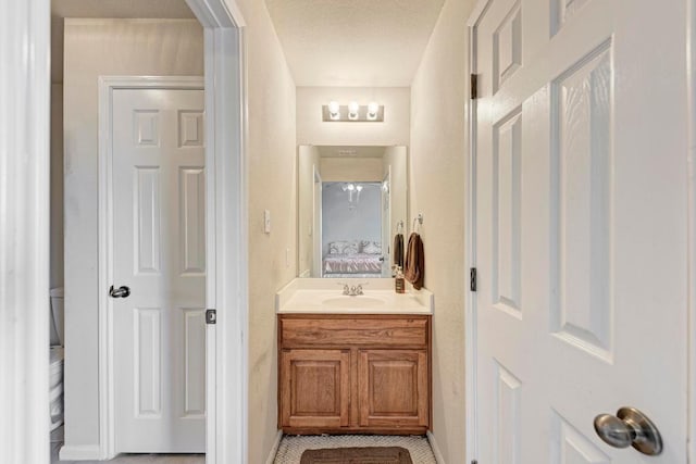 ensuite bathroom featuring vanity, tile patterned floors, baseboards, and ensuite bath