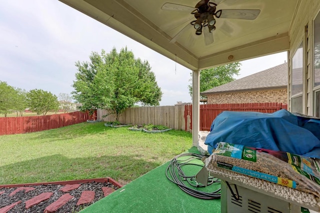 view of yard with a fenced backyard and ceiling fan