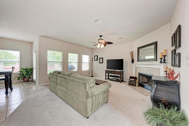 living room with ceiling fan, visible vents, a healthy amount of sunlight, and a fireplace