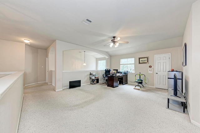 carpeted office space featuring baseboards, ceiling fan, arched walkways, and visible vents