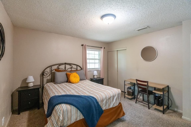 bedroom featuring a textured ceiling, visible vents, baseboards, a closet, and carpet