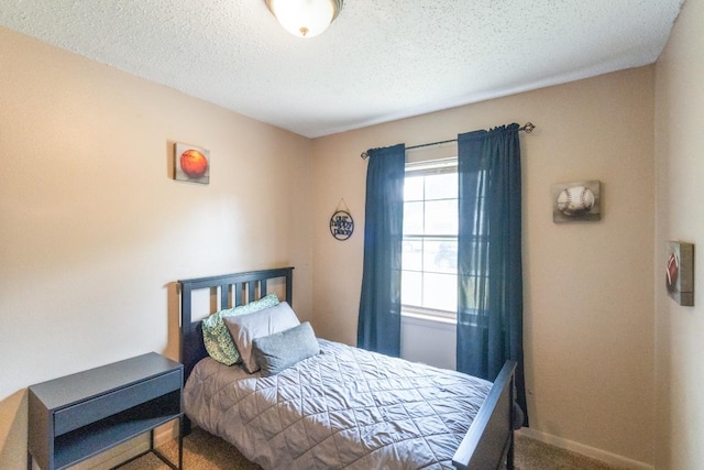 bedroom featuring carpet floors, a textured ceiling, and baseboards