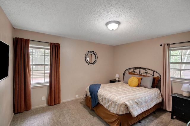 carpeted bedroom featuring baseboards and a textured ceiling