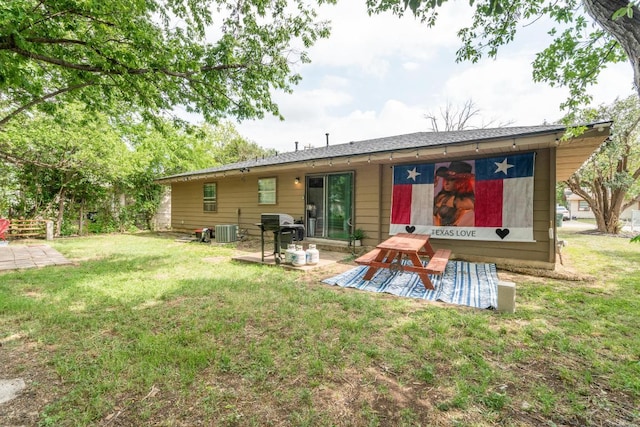 rear view of house with a lawn, a patio, and central AC