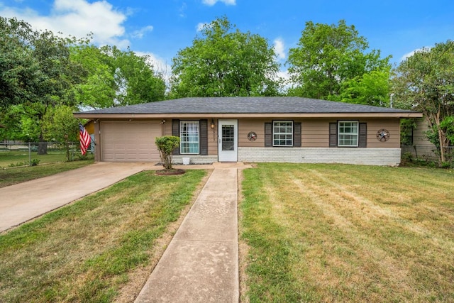 ranch-style home featuring concrete driveway, an attached garage, fence, and a front yard