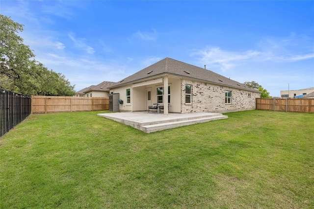 rear view of house featuring a yard, a patio, and a fenced backyard