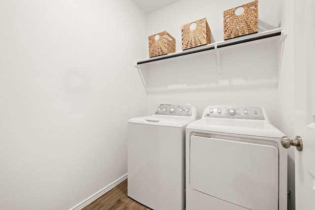 laundry room featuring washing machine and clothes dryer, laundry area, baseboards, and wood finished floors