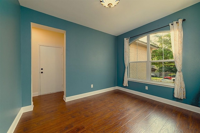 empty room with baseboards and wood finished floors
