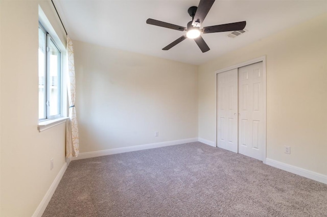 unfurnished bedroom featuring ceiling fan, visible vents, carpet, and a closet