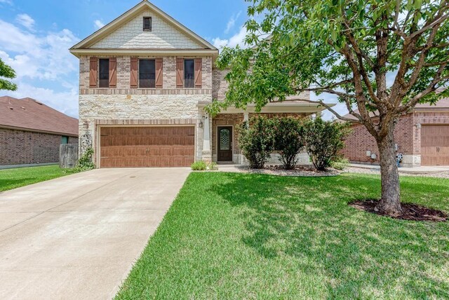 2119 Howell Mountain Dr, Cedar Park, TX 78613 - view of front of home with driveway, a front yard, a garage, stone siding, and brick siding