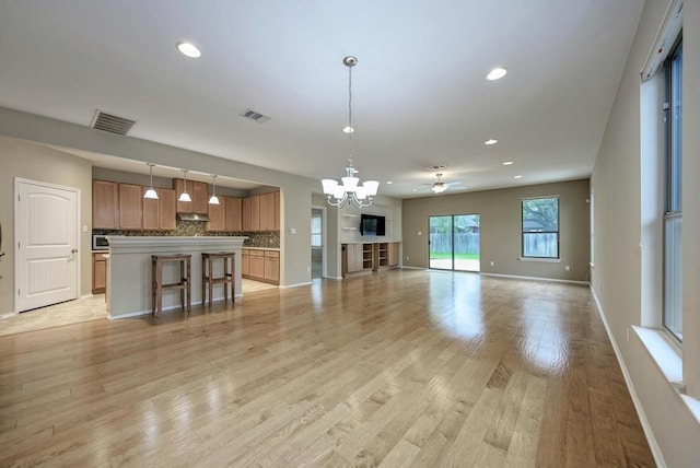 unfurnished living room with visible vents, recessed lighting, and baseboards